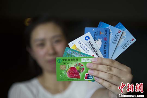 资料图：山西太原，民众展示银行卡。 <a target='_blank'  data-cke-saved-href='http://www.chinanews.com/' href='http://www.chinanews.com/'>中新社</a>记者 张云 摄